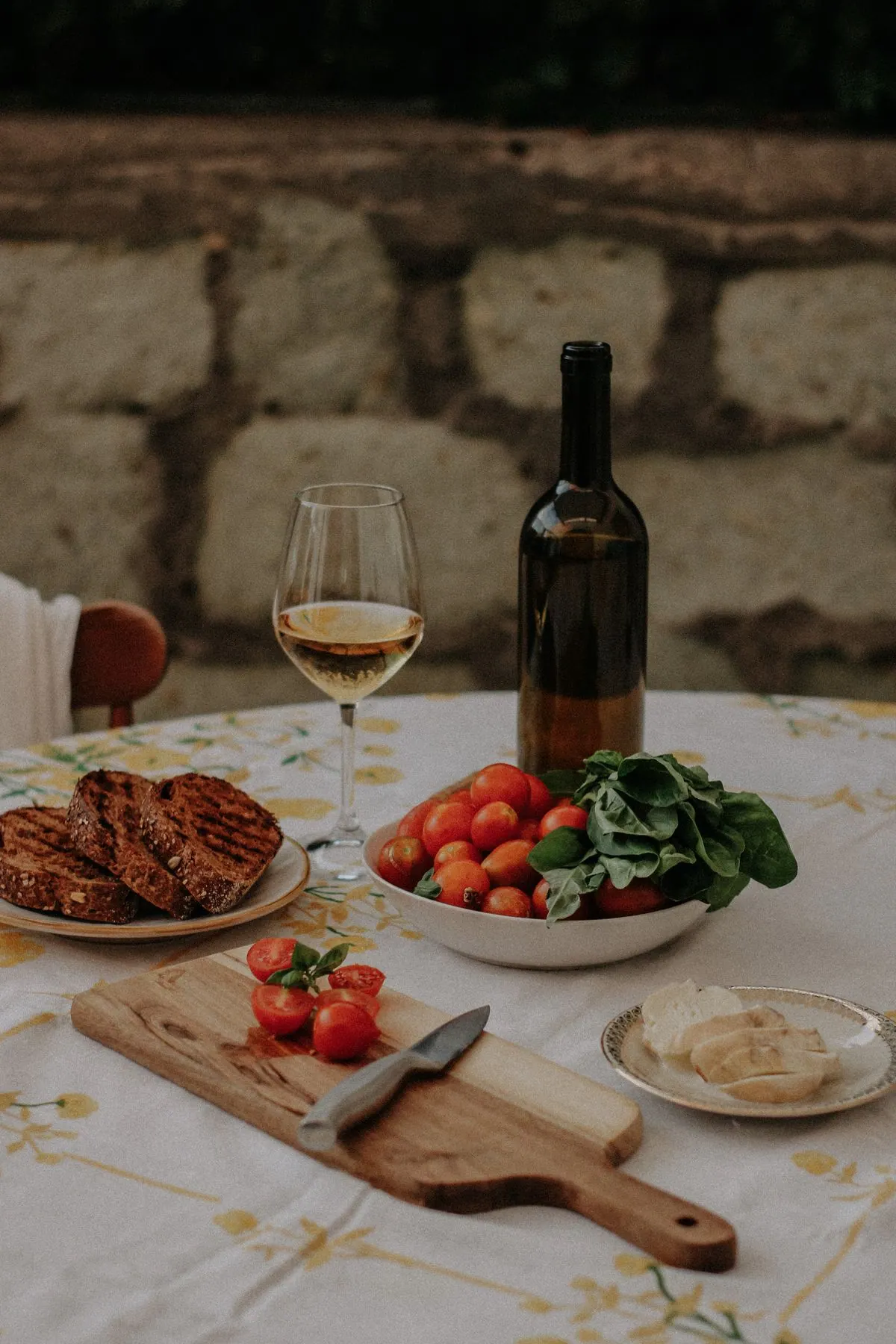 Mesa con pan, tomates y una copa de vino; fotografía ilustrativa